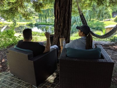 Couple relaxing by a willow pond on a cannabis tour
