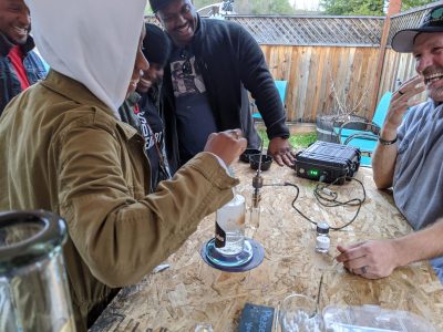 People laughing at an outdoor dab bar in The Emerald Triangle