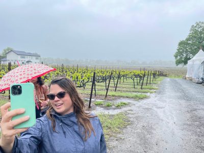 Tourists taking selfies in a vineyard on a weed and wine tour