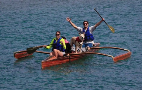 Tourists and a dog on an outrigger canoe
